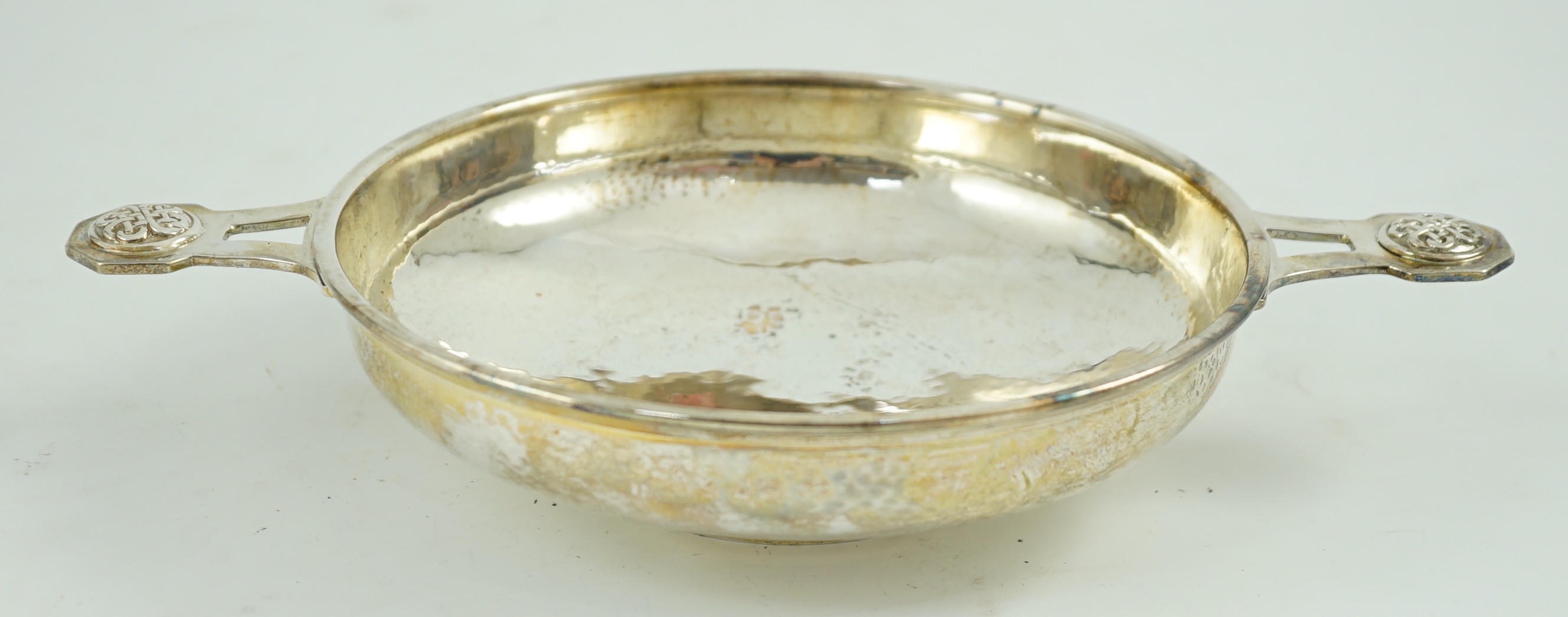 A George V Arts & Crafts planished silver two handled shallow dish, by Albert Edward Jones